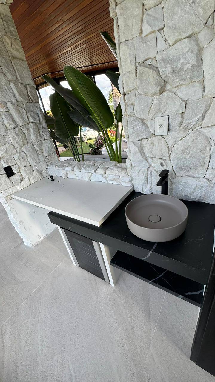 Detalhe de bancada gourmet em mármore claro com armários em madeira.